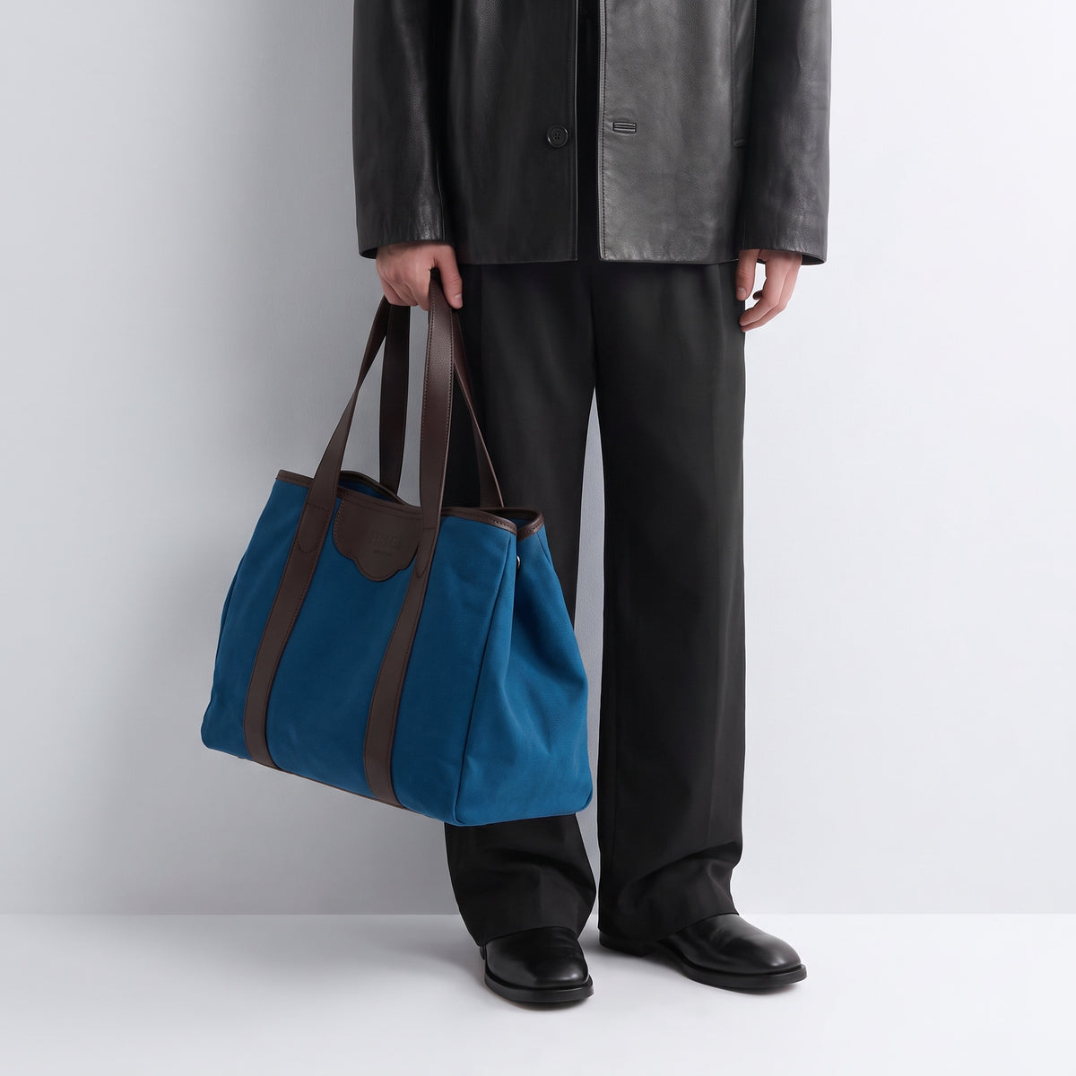 The à New York Grand Modèle in Deep Teal, carried with a black leather jacket